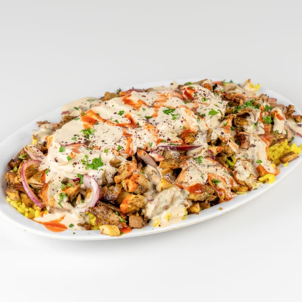 Falafel Hut's chicken and beef shawarma platter with rice, red onions, tahini, and hot sauce.